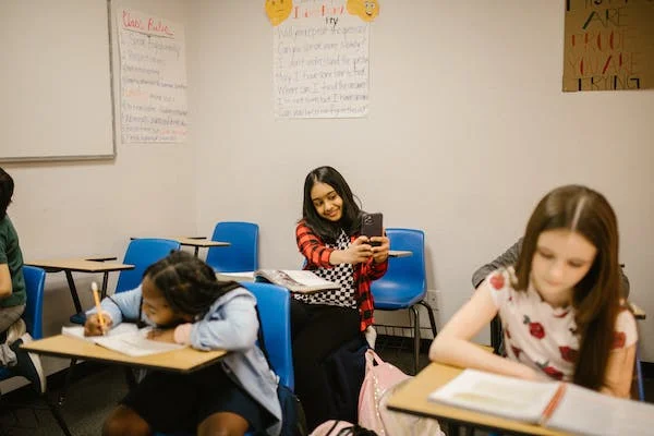 student taking a photo of another student in class could be the start of cyberbullying